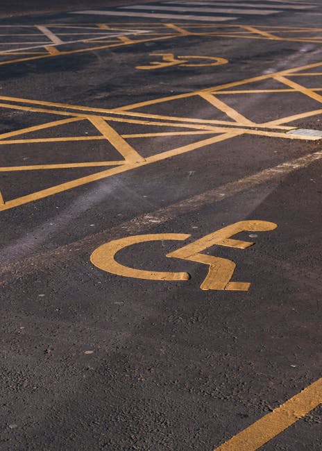 A metal parking restriction pole attached to a wall beneath a row of yellow-framed windows shows two parking restriction signs. The top sign indicates no parking except by permit from 7am to 6pm, Monday to Friday, with a red circle and slash over a letter P. The lower sign permits parking from 8am to 6pm, Monday to Friday, with a blue circle and letter P. The signs are mounted on a weathered pole that extends downward, partially obscured, and the background wall is made of stone or concrete with a textured surface, suggesting an urban environment suitable for house removals or furniture transport as facilitated by Removal Companies Pimlico.